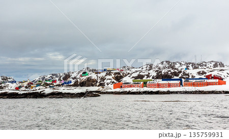 Living Inuit houses on the steep cliff covered in snow at the fjord, Maniitsoq Living Inuit houses on the steep cliff covered in snow at the fjord, Maniitsoq 135759931