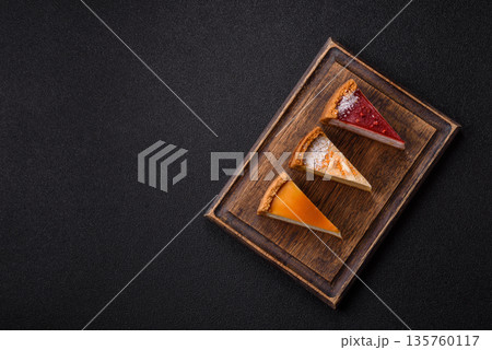 Cheesecake, a slice of sweet pie, a classic cheese dessert. Cheesecake as a food background Cheesecake, a slice of sweet pie, a classic cheese dessert. Cheesecake as a food background 135760117