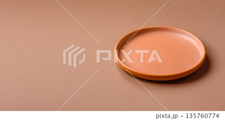 An empty round ceramic plate on a table, kitchenware. An empty plate An empty round ceramic plate on a table, kitchenware. An empty plate 135760774
