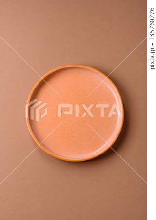 An empty round ceramic plate on a table, kitchenware. An empty plate An empty round ceramic plate on a table, kitchenware. An empty plate 135760776