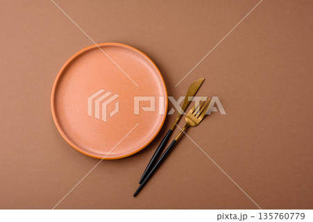 An empty round ceramic plate on a table, kitchenware. An empty plate 135760779