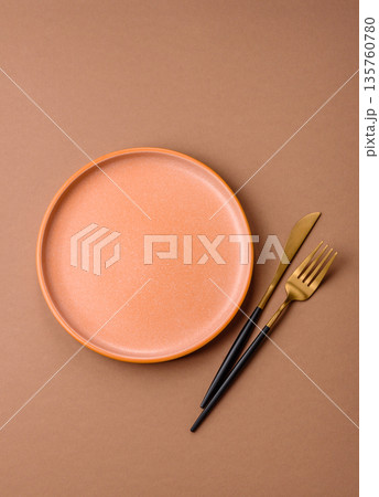 An empty round ceramic plate on a table, kitchenware. An empty plate An empty round ceramic plate on a table, kitchenware. An empty plate 135760780