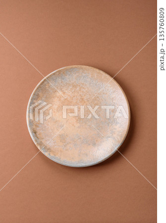 An empty round ceramic plate on a table, kitchenware. An empty plate An empty round ceramic plate on a table, kitchenware. An empty plate 135760809