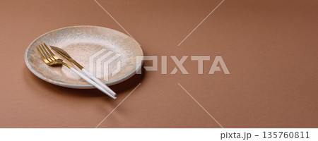 An empty round ceramic plate on a table, kitchenware. An empty plate 135760811
