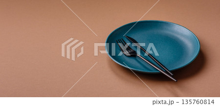 An empty round ceramic plate on a table, kitchenware. An empty plate An empty round ceramic plate on a table, kitchenware. An empty plate 135760814