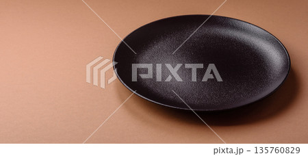An empty round ceramic plate on a table, kitchenware. An empty plate 135760829