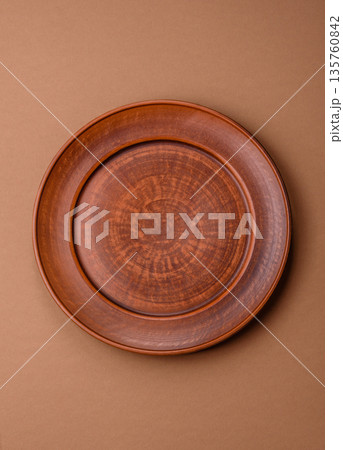 An empty round ceramic plate on a table, kitchenware. An empty plate An empty round ceramic plate on a table, kitchenware. An empty plate 135760842
