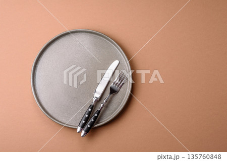 An empty round ceramic plate on a table, kitchenware. An empty plate An empty round ceramic plate on a table, kitchenware. An empty plate 135760848