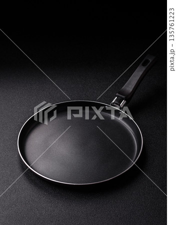 An empty black metal frying pan, kitchen utensils for cooking. An empty frying pan An empty black metal frying pan, kitchen utensils for cooking. An empty frying pan 135761223