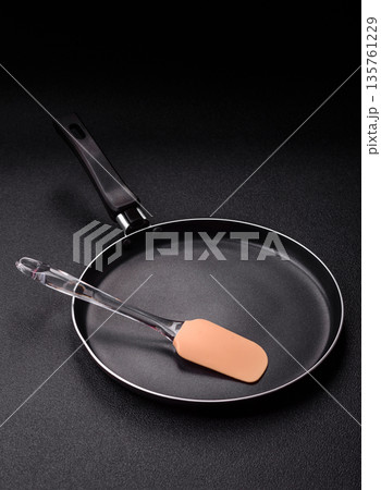 An empty black metal frying pan, kitchen utensils for cooking. An empty frying pan An empty black metal frying pan, kitchen utensils for cooking. An empty frying pan 135761229
