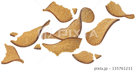 Falling thin rye bread croutons isolated on white background with clipping path, full depth of field Falling thin rye bread croutons isolated on white background with clipping path, full depth of field 135761231