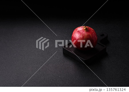 A juicy, ripe, whole red pomegranate as a source of beneficial nutrients. A whole red pomegranate A juicy, ripe, whole red pomegranate as a source of beneficial nutrients. A whole red pomegranate 135761324