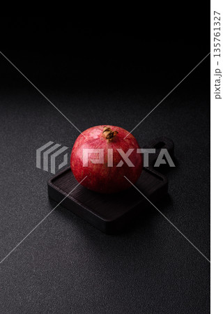 A juicy, ripe, whole red pomegranate as a source of beneficial nutrients. A whole red pomegranate A juicy, ripe, whole red pomegranate as a source of beneficial nutrients. A whole red pomegranate 135761327