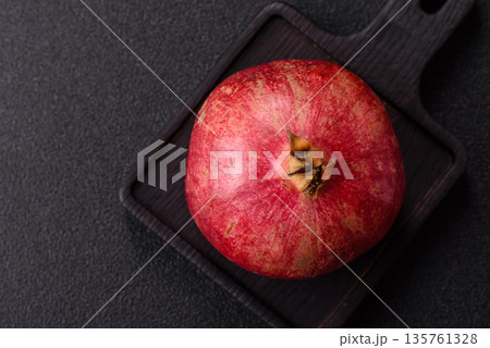 A juicy, ripe, whole red pomegranate as a source of beneficial nutrients. A whole red pomegranate A juicy, ripe, whole red pomegranate as a source of beneficial nutrients. A whole red pomegranate 135761328