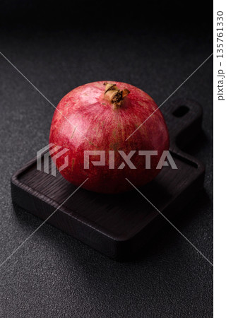 A juicy, ripe, whole red pomegranate as a source of beneficial nutrients. A whole red pomegranate A juicy, ripe, whole red pomegranate as a source of beneficial nutrients. A whole red pomegranate 135761330