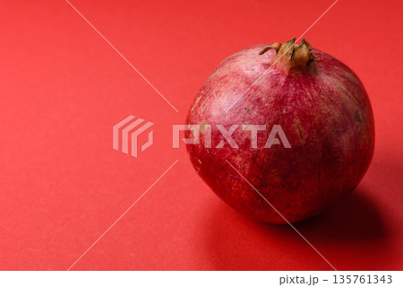 A juicy, ripe, whole red pomegranate as a source of beneficial nutrients. A whole red pomegranate A juicy, ripe, whole red pomegranate as a source of beneficial nutrients. A whole red pomegranate 135761343