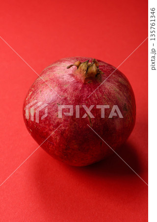 A juicy, ripe, whole red pomegranate as a source of beneficial nutrients. A whole red pomegranate A juicy, ripe, whole red pomegranate as a source of beneficial nutrients. A whole red pomegranate 135761346