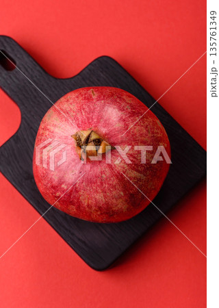A juicy, ripe, whole red pomegranate as a source of beneficial nutrients. A whole red pomegranate 135761349