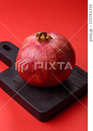 A juicy, ripe, whole red pomegranate as a source of beneficial nutrients. A whole red pomegranate A juicy, ripe, whole red pomegranate as a source of beneficial nutrients. A whole red pomegranate 135761350