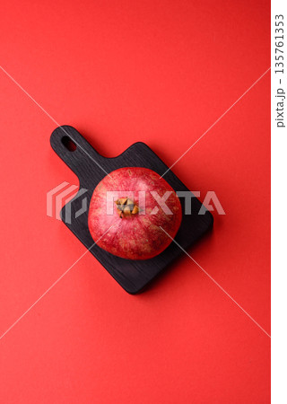 A juicy, ripe, whole red pomegranate as a source of beneficial nutrients. A whole red pomegranate 135761353