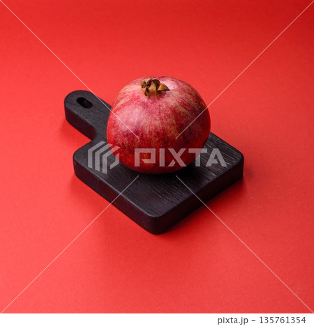 A juicy, ripe, whole red pomegranate as a source of beneficial nutrients. A whole red pomegranate A juicy, ripe, whole red pomegranate as a source of beneficial nutrients. A whole red pomegranate 135761354