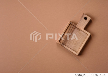 Wood, a wooden empty cutting board on a dark kitchen table. Wooden cutting board Wood, a wooden empty cutting board on a dark kitchen table. Wooden cutting board 135761403