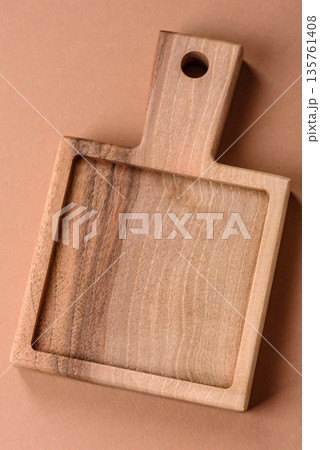 Wood, a wooden empty cutting board on a dark kitchen table. Wooden cutting board Wood, a wooden empty cutting board on a dark kitchen table. Wooden cutting board 135761408