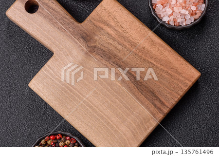Wood, a wooden empty cutting board on a dark kitchen table. Wooden cutting board 135761496