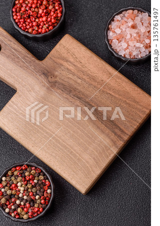 Wood, a wooden empty cutting board on a dark kitchen table. Wooden cutting board Wood, a wooden empty cutting board on a dark kitchen table. Wooden cutting board 135761497
