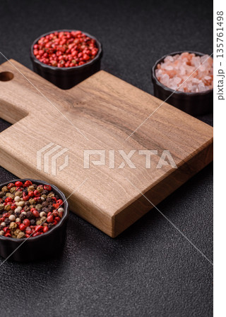 Wood, a wooden empty cutting board on a dark kitchen table. Wooden cutting board Wood, a wooden empty cutting board on a dark kitchen table. Wooden cutting board 135761498