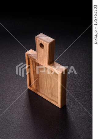 Wood, a wooden empty cutting board on a dark kitchen table. Wooden cutting board Wood, a wooden empty cutting board on a dark kitchen table. Wooden cutting board 135761503