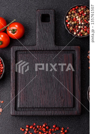 Wood, a wooden empty cutting board on a dark kitchen table. Wooden cutting board Wood, a wooden empty cutting board on a dark kitchen table. Wooden cutting board 135761507