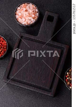 Wood, a wooden empty cutting board on a dark kitchen table. Wooden cutting board Wood, a wooden empty cutting board on a dark kitchen table. Wooden cutting board 135761517