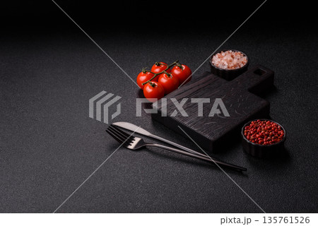 Wood, a wooden empty cutting board on a dark kitchen table. Wooden cutting board Wood, a wooden empty cutting board on a dark kitchen table. Wooden cutting board 135761526