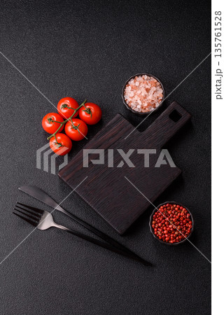 Wood, a wooden empty cutting board on a dark kitchen table. Wooden cutting board Wood, a wooden empty cutting board on a dark kitchen table. Wooden cutting board 135761528