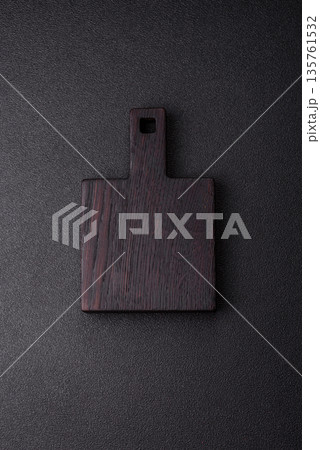 Wood, a wooden empty cutting board on a dark kitchen table. Wooden cutting board 135761532