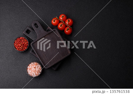 Wood, a wooden empty cutting board on a dark kitchen table. Wooden cutting board Wood, a wooden empty cutting board on a dark kitchen table. Wooden cutting board 135761538