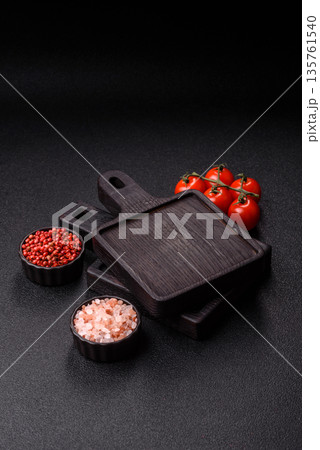 Wood, a wooden empty cutting board on a dark kitchen table. Wooden cutting board Wood, a wooden empty cutting board on a dark kitchen table. Wooden cutting board 135761540