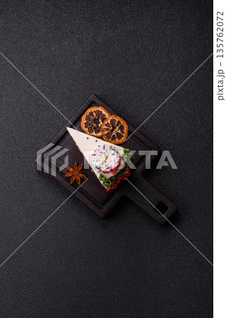 A slice of sweet layered cake with a Christmas ornament and fruit flavor. A slice of cake A slice of sweet layered cake with a Christmas ornament and fruit flavor. A slice of cake 135762072