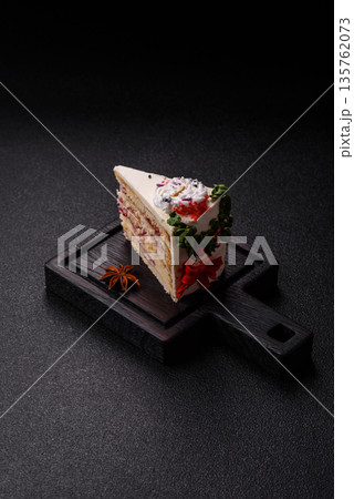 A slice of sweet layered cake with a Christmas ornament and fruit flavor. A slice of cake 135762073