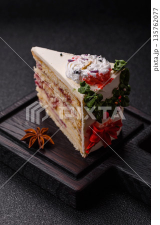 A slice of sweet layered cake with a Christmas ornament and fruit flavor. A slice of cake 135762077