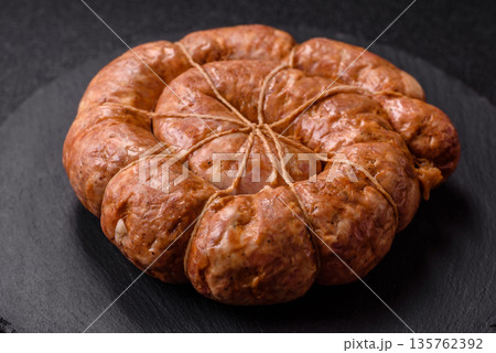 Grilled sausage in the shape of a spiral or snail, from chicken or pork. Spiral or snail sausage 135762392