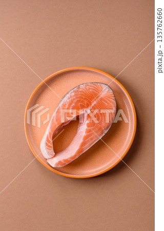 Fish, raw salmon steak, fresh seafood for grilling with salt, spices, and herbs. Raw salmon steak Fish, raw salmon steak, fresh seafood for grilling with salt, spices, and herbs. Raw salmon steak 135762660