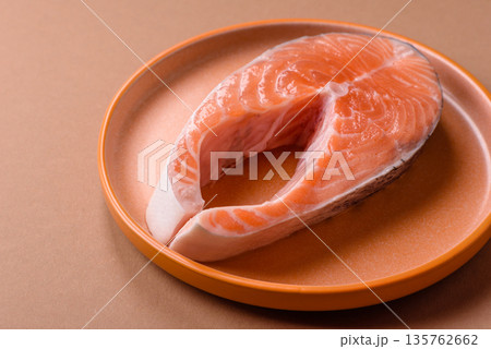 Fish, raw salmon steak, fresh seafood for grilling with salt, spices, and herbs. Raw salmon steak 135762662