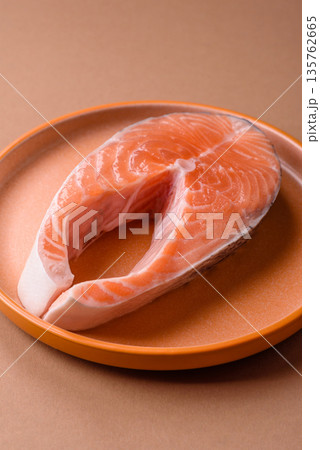 Fish, raw salmon steak, fresh seafood for grilling with salt, spices, and herbs. Raw salmon steak Fish, raw salmon steak, fresh seafood for grilling with salt, spices, and herbs. Raw salmon steak 135762665