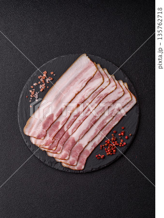 Raw smoked bacon slices, ham, jamon, or prosciutto strips for cooking. Raw bacon slices Raw smoked bacon slices, ham, jamon, or prosciutto strips for cooking. Raw bacon slices 135762718