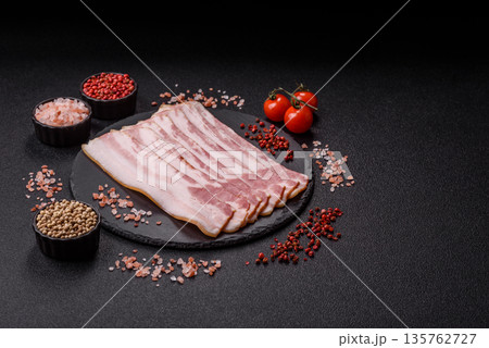Raw smoked bacon slices, ham, jamon, or prosciutto strips for cooking. Raw bacon slices Raw smoked bacon slices, ham, jamon, or prosciutto strips for cooking. Raw bacon slices 135762727