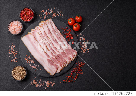 Raw smoked bacon slices, ham, jamon, or prosciutto strips for cooking. Raw bacon slices Raw smoked bacon slices, ham, jamon, or prosciutto strips for cooking. Raw bacon slices 135762728