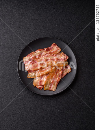 Fried smoked bacon slices, ham, jamon, or prosciutto strips for cooking. Fried bacon Fried smoked bacon slices, ham, jamon, or prosciutto strips for cooking. Fried bacon 135762732