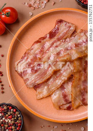 Fried smoked bacon slices, ham, jamon, or prosciutto strips for cooking. Fried bacon Fried smoked bacon slices, ham, jamon, or prosciutto strips for cooking. Fried bacon 135762751